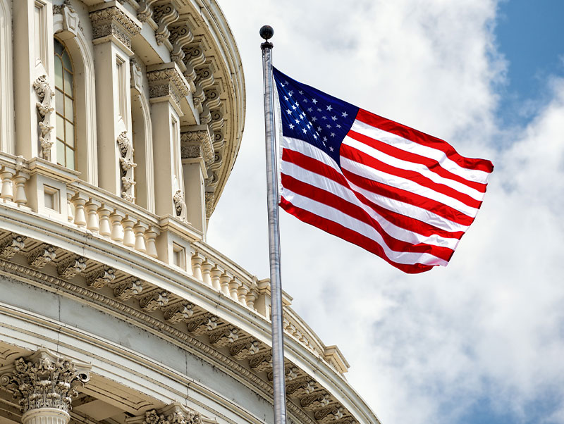 Exterior of US Capital with flag waving in the breeze